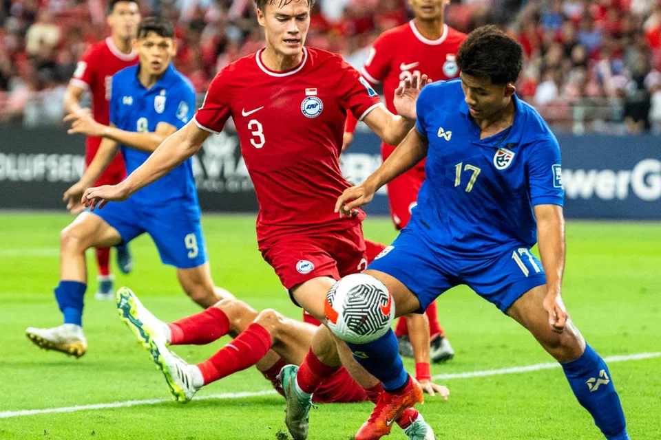 GIGIT JARI: Pemain Singapura, Ryhan Stewart (kiri) cuba mendapatkan bola dari pemain Thailand, Suphanat Mueanta (kanan) dalam aksi kedua pusingan kedua Kelayakan Piala Dunia 2026 di Stadium Negara pada Selasa.
