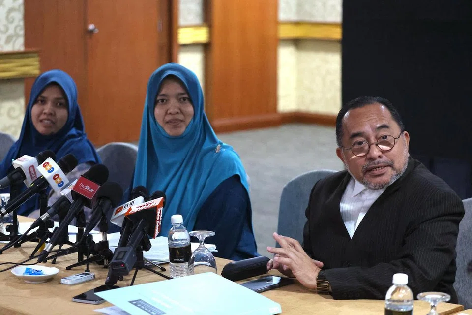Peguam Encik Rosli Kamaruddin (kanan) dan anak pengasas Al-Arqam yang juga ahli Global Ikhwan Service and Business (GISBH), Cik Khaulah Ashaari (tengah), dalam sidang media di Shah Alam, pada 14 Oktober.