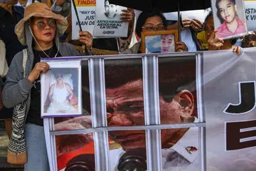 Keluarga mangsa pembunuhan di luar proses undang-undang dalam perang dadah bekas presiden Filipina Rodrigo Duterte (gambar pada sepanduk) mempamerkan potret orang tersayang mereka ketika protes di Manila pada 23 Februari 2026. Satu pendengaran bermula di Mahkamah Jenayah Antarabangsa (ICC) pada hari yang sama bagi menentukan sama ada Duterte akan dibicarakan berhubung sekurang-kurangnya 76 kematian tersebut. 