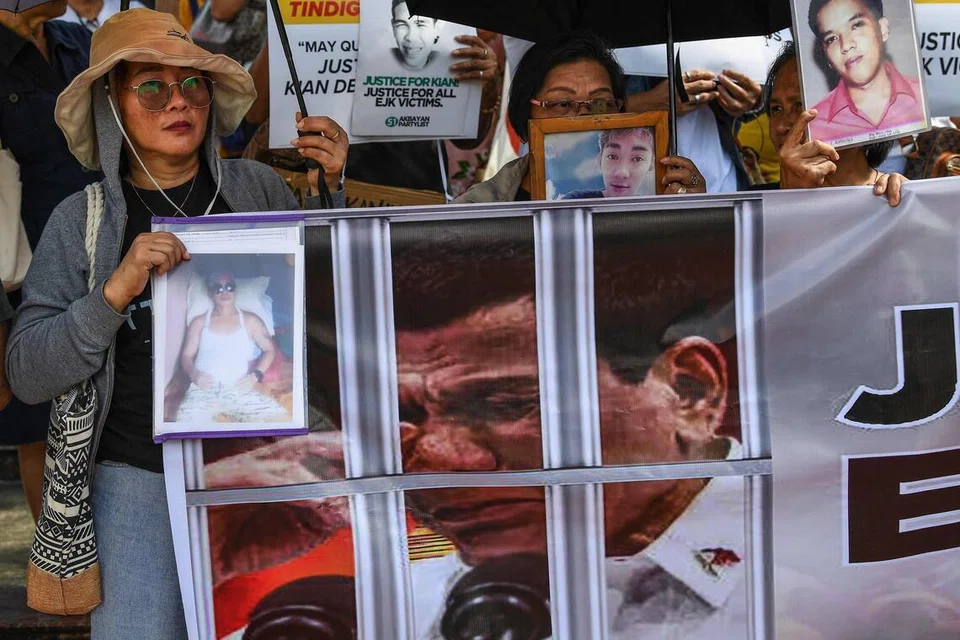 Keluarga mangsa pembunuhan di luar proses undang-undang dalam perang dadah bekas presiden Filipina Rodrigo Duterte (gambar pada sepanduk) mempamerkan potret orang tersayang mereka ketika protes di Manila pada 23 Februari 2026. Satu pendengaran bermula di Mahkamah Jenayah Antarabangsa (ICC) pada hari yang sama bagi menentukan sama ada Duterte akan dibicarakan berhubung sekurang-kurangnya 76 kematian tersebut. 