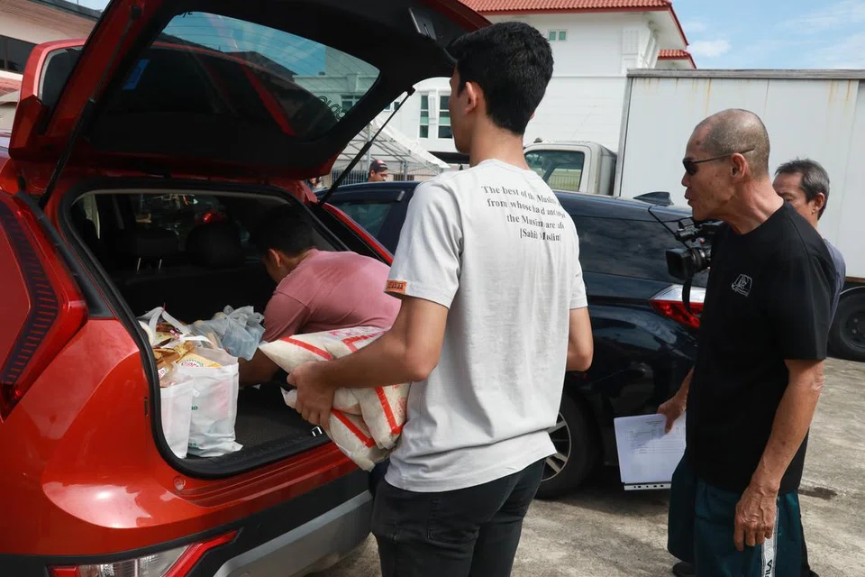 Sukarelawan dari Muhammadiyah bergotong royong membuat pengagihan barangan keperluan pra-Ramadan kepada yang memerlukan.