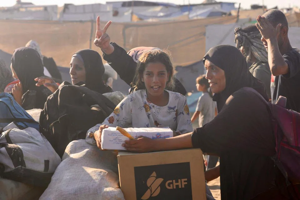 Penduduk Palestin berjalan di sepanjang Jalan al-Rashid di barat Jabalia pada 24 Julai 2025, selepas menerima bantuan kemanusiaan dari pusat agihan bantuan di utara Semenanjung Gaza. Lebih 100 organisasi bantuan memberi amaran pada 23 Julai bahawa “kebuluran besar-besaran” sedang merebak di seluruh Gaza, dan rakan-rakan mereka sendiri turut terjejas teruk akibat kekurangan bekalan. (