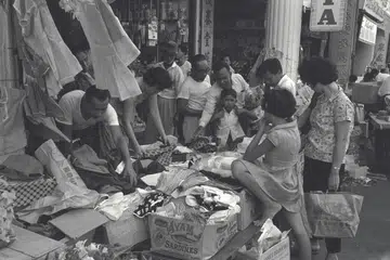 Sekumpulan pelanggan sibuk memilih pakaian di kedai yang mengadakan jualan istimewa sempena musim perayaan Hari Raya. Gambar ini dirakamkan pada 31 Januari 1965. 
