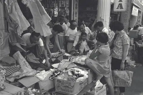 Sekumpulan pelanggan sibuk memilih pakaian di kedai yang mengadakan jualan istimewa sempena musim perayaan Hari Raya. Gambar ini dirakamkan pada 31 Januari 1965. 
