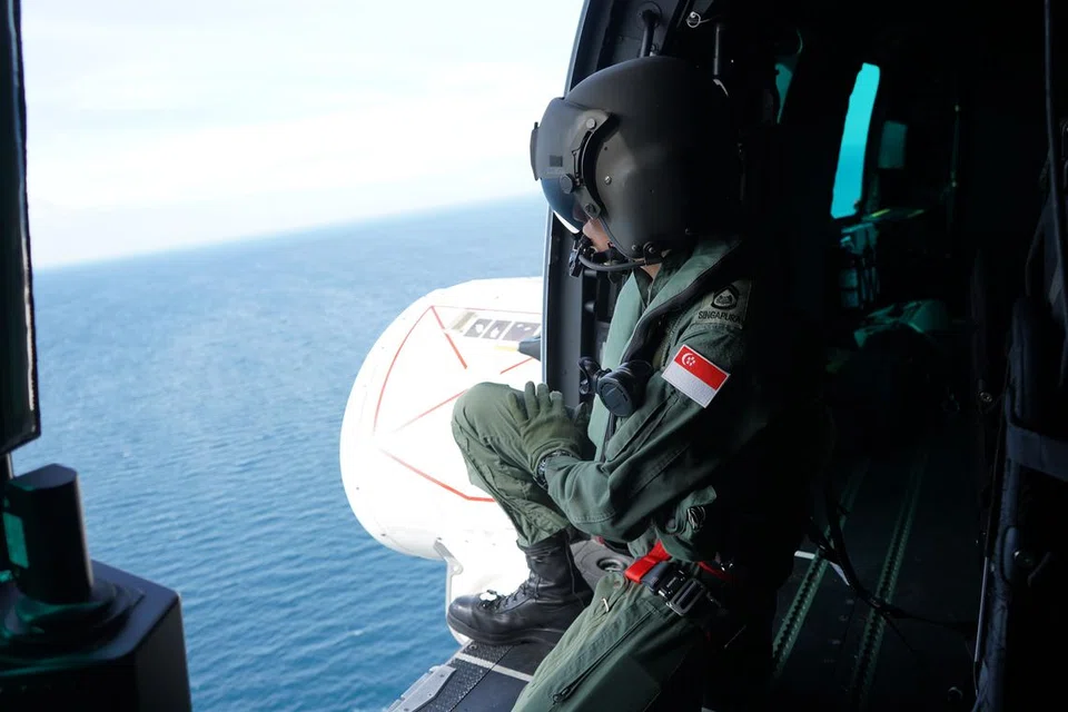 USAHA MENCARI: Seorang kru udara RSAF menjalankan pencarian bagi mereka yang masih hidup sebagai sebahagian daripada simulasi senario kemalangan udara. 