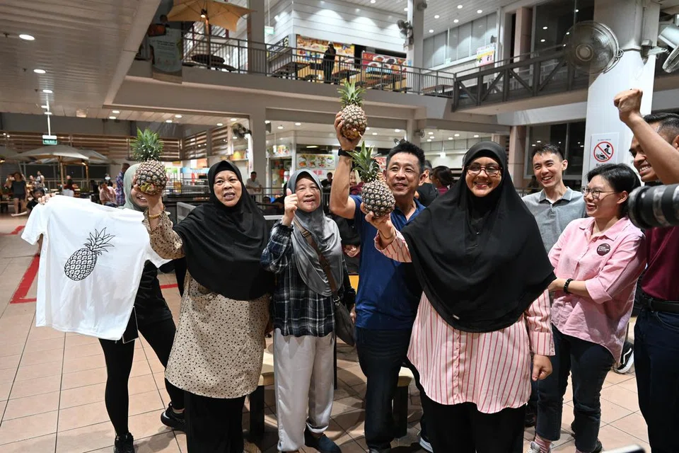 BAWA ‘NANAS’: Ramai dalam kalangan penyokong Encik Tharman membawa nanas ke Pusat Penjaja Taman Jurong, di mana sekitar 500 penyokong Encik Tharman berhimpun pada Jumaat. 