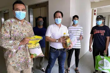HULUR BANTUAN: Encik Sharael (kiri) bersama relawan semasa pengagihan pek keperluan dapur untuk penduduk GRC Pasir Ris-Punggol pada Ramadan tahun lalu. - Foto M³@PASIR RIS-PUNGGOL
