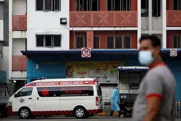 LANGKAH TANGKAS: Ambulans berada di Dormitori Westlite Woodlands selepas beberapa pekerja asing yang sudah pulih dikesan mendapat Covid-19. - Foto REUTERS