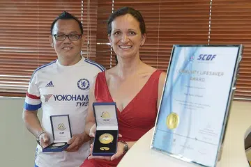 USAHA MENYELAMAT DIHARGAI: Encik Tan Kian Choon dan Cik Silvia Hajas menerima anugerah SCDF atas usaha mereka membantu menyelamatkan tiga kanak-kanak lelaki yang hampir lemas di Taman East Coast baru-baru ini. - Foto THE STRAITS TIMES