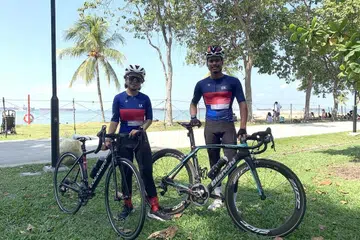 TIDAK SESIAKAN CUTI: Encik Mohammad Haizal (kanan) dan Cik Nur Fatin (kiri) berbasikal di pantai East Coast. - Foto oleh NUR SYUHRAH HASSAN.
