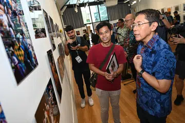 (Dari kanan) Menteri Kedua (Ehwal Luar merangkap Pendidikan), Dr Mohamad Maliki Osman  meninjau pameran foto di galeri Kamal Arts pada 24 Ogos bersama Pengasas Studio Kamal Arts, Encik Kamal  Dollah dan pekerja sosial, Encik Muhamad ‘Izuddin Sufian Sujai.