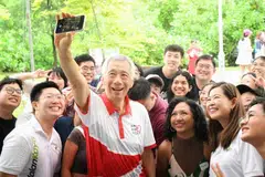 Menteri Kanan Encik Lee Hsien Loong (dua dari kiri) dan Penasihat kepada Pertubuhan Akar Umbi (GRO) GRC Ang Mo Kio, Cik Ng Ling Ling (dua dari kanan), bergambar bersama para peserta perbincangan kendalian Friendzone semasa acara Hari Jalan Kayu 2024 pada 7 Julai.