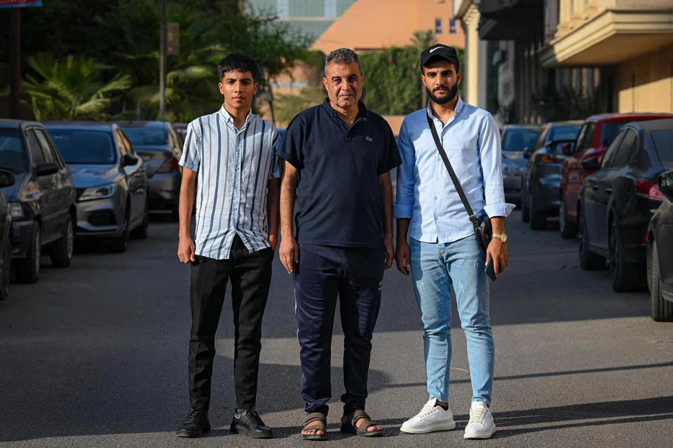 MASIH BERSAMA:  Encik Akmal Galeb Abo Khodra (tengah) bersama dua anak lelakinya, Encik Khalid Akmal Galeb (kanan) dan Encik Mohamed Akmal Galeb di Rafah. Mereka melarikan diri ke Mesir dari Gaza sehelai sepinggang dan hanya membawa beg sandang berisi keperluan penting. 