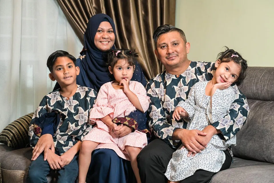 Cik Dayana memangku anak-anaknya Mohamad Dhaffir Rafael (kiri) dan Mikayla Nazra (tengah) bersama suaminya Encik Mohamad Ridhwan Shahul Hamid (kanan) yang mendukung anak mereka Mikayla Sabira.