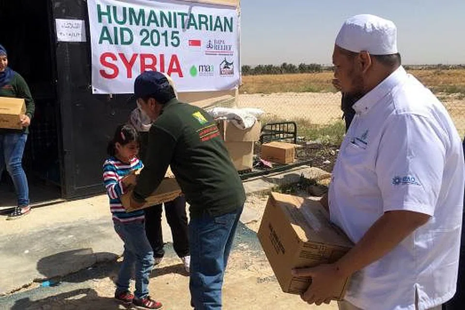 HULUR BANTUAN: Sukarelawan BAPA ketika mengagihkan bantuan kepada pelarian Syria. Kempen kumpul dana kecemasan untuk tujuan tersebut bakal berakhir pada 31 Disember ini.- Foto-foto BAPA