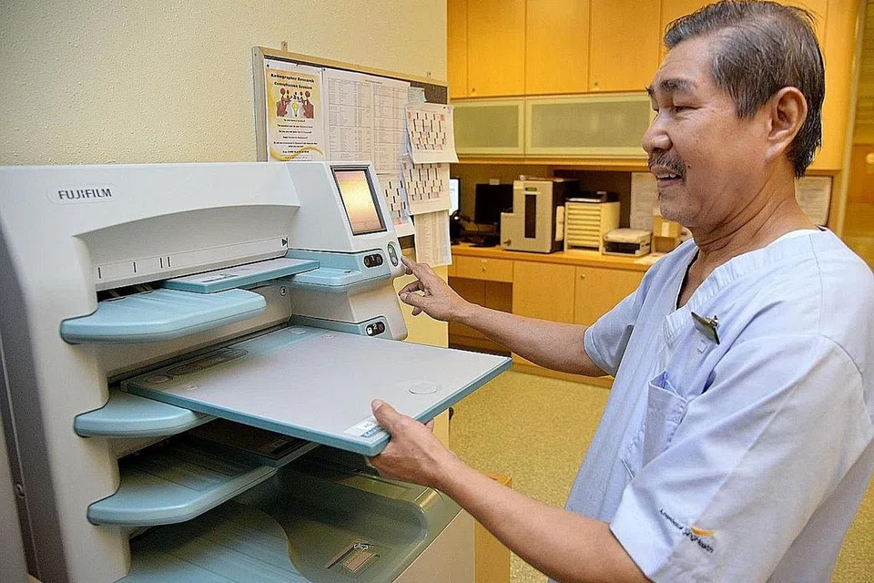 SAKSIKAN PELBAGAI PERUBAHAN DALAM BIDANG KERJA: Encik Md Shah Walat, 65 tahun, bertugas sebagai teknisyen gambar di jabatan radiologi diagnostik di SGH sejak 40 tahun lalu. Beliau membantu jururadiografi memproses gambar X-ray yang diambil menerusi mesin pemprosesan imej. - Foto SHAKIR SAIFUDDIN