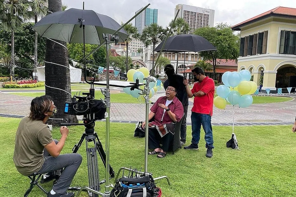 PERSIAPAN BAGI MINGGU MEMBACA: Di sebalik tabir acara 'Membaca di Bawah Bintang' sempena Minggu Membaca Raikan Ilmu anjuran Yayasan Mendaki, yang turut melibatkan selebriti Suhaimi Yusof (duduk menghadap kamera). Acara tersebut diadakan dalam talian tahun ini disebabkan sekatan Covid-19. - Foto YAYASAN MENDAKI