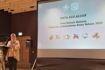  Pengerusi Jawatankuasa Bulan Bahasa 2023 Cik Rahayu Mahzam memberi taklimat kepada rakan kerjasama.