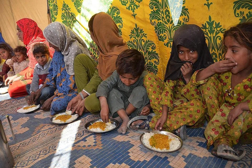 NASIB WARGA PAKISTAN: Mangsa banjir yang terjejas akibat banjir diberi makanan percuma berdekatan sebuah kem sementara di kawasan Dera Allah Yar di kawasan Dera Allah Yar di daerah Jaffarabad, wilayah Balochistan, Pakistan. - Foto AFP