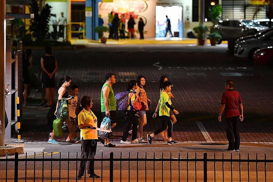 TERPAKSA PULANG: Beberapa pelajar kelihatan di luar kawasan Sekolah Rendah Punggol selepas pulang daripada perkhemahan yang terpaksa dipendekkan, selepas pelajar dan guru dilaporkan mengalami ciri-birit dan sakit perut semasa perkhemahan itu. - Foto BM oleh LIM YAOHUI