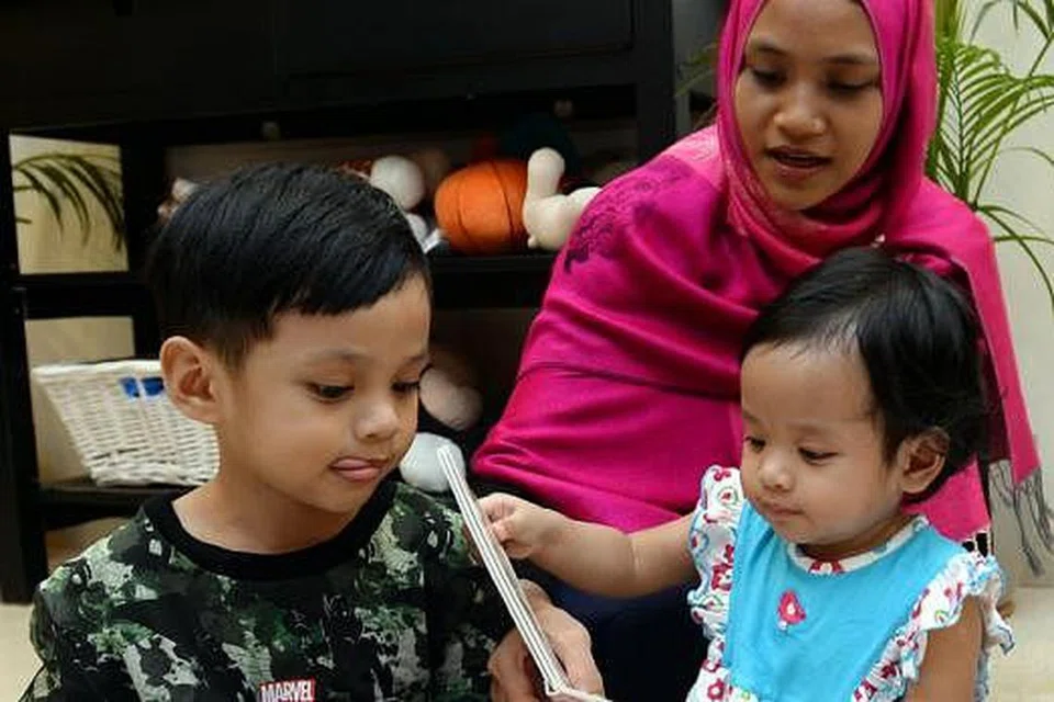 DAPATKAN PENDAPAT PAKAR: Cik Ildasolha Jamari mendapatkan pandangan bukan sahaja ahli keluarga, malah guru subjek Bahasa Melayu dan para penceramah NIE, bagi menghasilkan buku-bukunya. (Gambar) Cik Ildasolha mengenalkan dua anaknya, Shaikh Uthman Shahzeb Muhammad Jemal (kiri) dan Hafsah Begum Muhmmad Jemal, membaca buku di rumah.