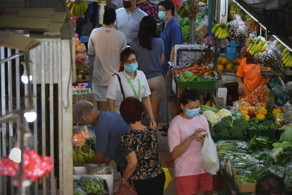 Seorang pegawai Agensi Sekitaran Kebangsaan (berbaju putih) di Pusat Makanan dan Pasar Bukit Timah, pada 12 April. 