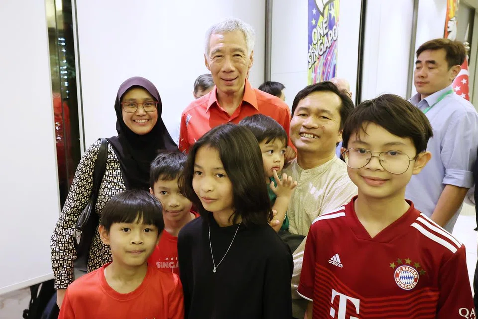 CIPTA KENANGAN: Profesor Zuruzi Abu Samah (mendukung anak) dan isteri, Cik Nurmawati Muhammad Hanafiah (bertudung), bersama anak-anak bergambar dengan Encik Lee Hsien Loong di majlis jamuan bagi warga Singapura di Kedutaan Singapura di Riyadh semasa lawatan rasmi Encik Lee ke Saudi pada Oktober.