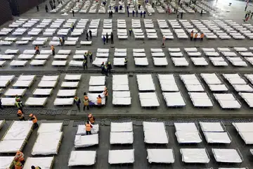 KATIL TAMBAHAN: Pekerja menyusun katil di hospital mudah alih dengan 2,000 katil yang dibangunkan di sebuah pusat pameran di Wuhan. 