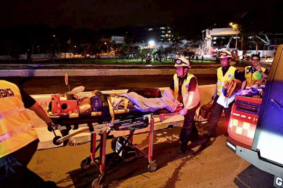 CEDERA: Paramedik bergegas membantu pekerja yang cedera ekoran struktur yang runtuh dekat PIE menghala barat, semasa mereka sedang bekerja.