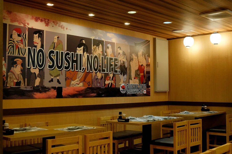 Mural gergasi bertulis ‘NO SUSHI, NO LIFE’  dengan ilustrasi karakter Jepun klasik pada dinding restoran mencuri tumpuan penulis.