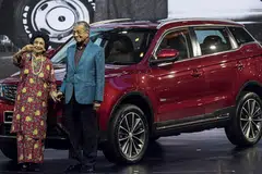 HARAP JADI KEBANGGAAN NEGARA: Dr Mahathir dan isteri Tun Dr Siti Hasmah bergambar di hadapan kereta jenis SUV, X70, yang dihasilkan menyusuli kerja sama Proton dan syarikat automotif dari China, Geely. - Foto EPA-EFE