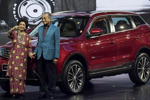 HARAP JADI KEBANGGAAN NEGARA: Dr Mahathir dan isteri Tun Dr Siti Hasmah bergambar di hadapan kereta jenis SUV, X70, yang dihasilkan menyusuli kerja sama Proton dan syarikat automotif dari China, Geely. - Foto EPA-EFE