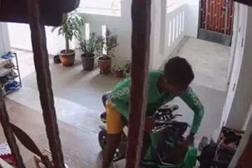 DIDAKWA CURI KASUT: Satu video yang dimuat naik ke media sosial menunjukkan seorang penghantar GrabFood mengambil sepasang kasut dan memasukkannya ke dalam begnya sebelum pergi.
