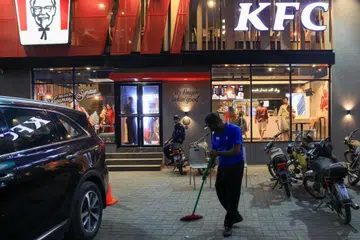 Seorang pekerja membersihkan lantai di luar cawangan KFC selepas diserang penunjuk perasaan di Pakistan pada 17 April. Serangan dipercayai akibat  sentimen anti-Amerika dan bantahan terhadap perang di Gaza.