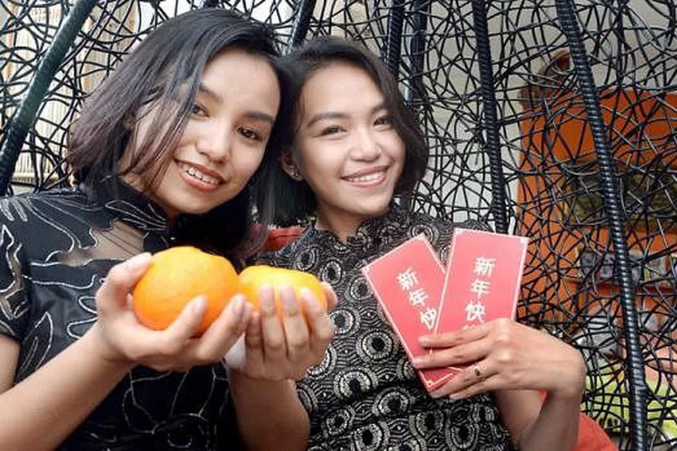 MELESTARIKAN TRADISI: Walaupun Cik Hazirah Hafiz Howe (kanan) dan adiknya, Cik Haziqah, berpakaian hitam, sesuatu yang tidak digalakkan semasa perayaan Tahun Baru Cina kerana ia melambangkan kematian, pemikiran tersebut telah dipermodenkan dan mereka masih tetap berpegang teguh kepada adat istiadat masyarakat Cina semasa perayaan Tahun Baru CIna. - Foto TAUFIK A. KADER