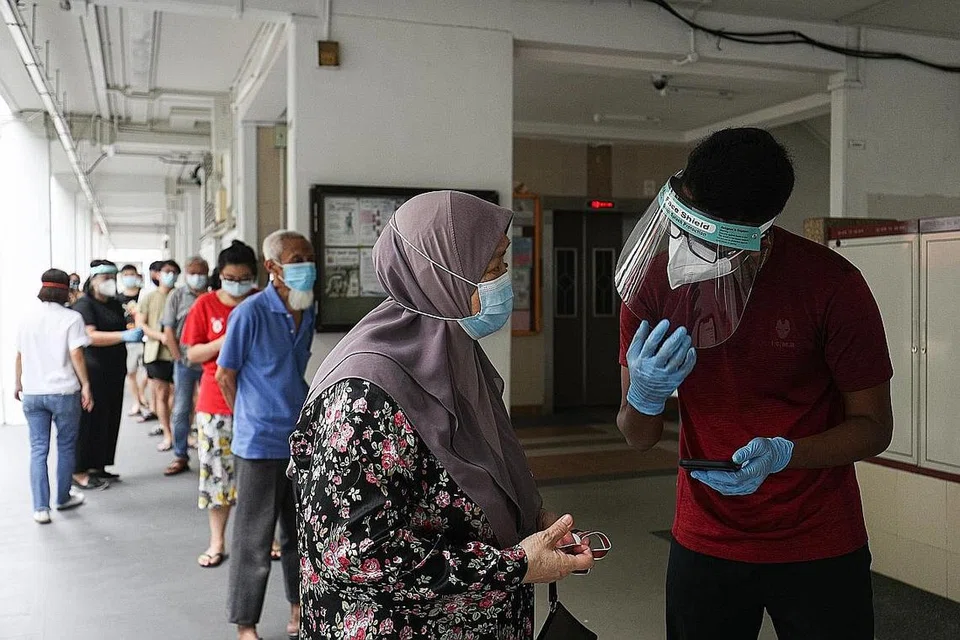 PUTUSKAN RANTAIAN JANGKITAN VIRUS: Penduduk dan pengunjung ke blok Hougang yang terjejas beratur di kolong Blok 506 untuk menjalani ujian swab Covid-19 baru-baru ini. - Foto ZAOBAO