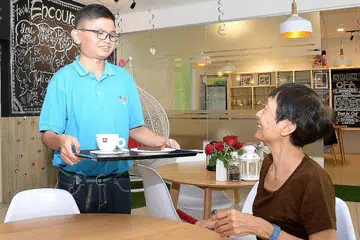 LATIHAN SAMBIL KERJA: Pelajar berkeperluan khas Encik Muhammad Muhaimin Mohd Afandi bersyukur dengan latihan yang disediakan Pusat Dewasa APSN untuk bekerja di kafe Mystical Cafe For All bagi mempersiapkannya untuk dunia pekerjaan. - Foto ZAINAL YAHYA