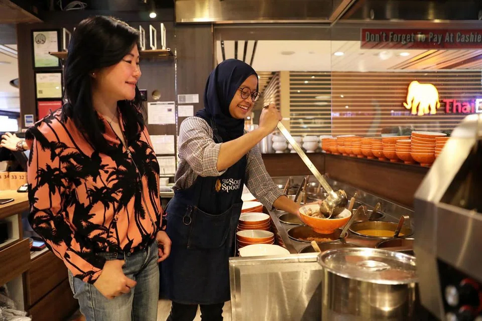 DAPAT PERHATIAN: Sup yang disediakan seorang kakitangan, Cik Siti Nurzana Abd Hamid, dan diperhatikan Cik Anna Lim (kiri) terus dapat perhatian di restoran The Soup Spoon Union yang menggabungkan tiga jenama lain. - Foto BM oleh GIN TAY