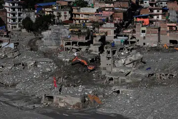 Sebuah jengkaut membersihkan lumpur di kawasan rumah yang rosak akibat banjir kilat dan tanah runtuh di daerah Nuwakot, Nepal, pada 21 September 2026. Bencana yang melanda negara itu pada Ogos lalu meragut sekurang-kurangnya 1,400 nyawa, manakala lebih 6,000 orang masih hilang. Perdana Menteri Nepal, Encik Balendra Shah, memberi amaran kepada PBB bahawa perubahan iklim yang mempercepat pencairan glasier di Himalaya meningkatkan risiko bencana dan menggesa bantuan antarabangsa bagi usaha pemulihan