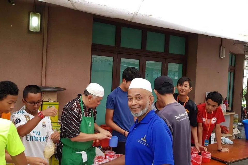 Sejak lebih dua dekad lalu, Encik Salil Mohamed Ali (depan, berbaju biru) aktif di Masjid Alkaff Kampung Melayu dan menyambut baik kerja peningkatan masjid. Gambar kenangan membungkus bubur sempena Ramadan.