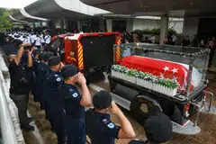 Pegawai SCDF kelihatan memberi salut kepada keranda Sarjan (1) Edward H. Go dalam satu upacara pada 13 Disember 2022. - 