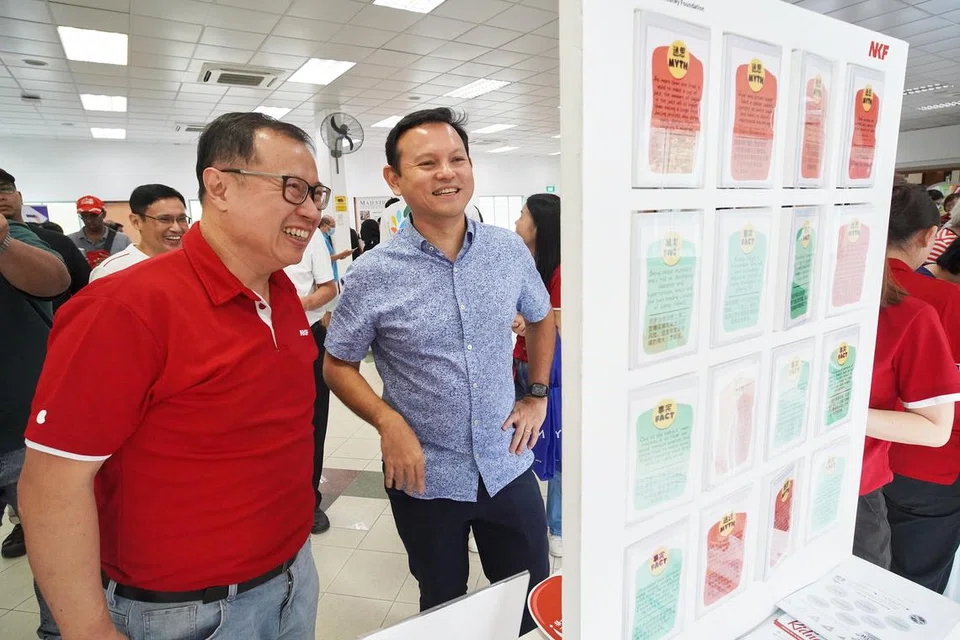 TINGKAT KESEDARAN: Menteri Negara Kanan (Tenaga Manusia merangkap Pertahanan) Encik Zaqy Mohamad (kanan) dibawa meneroka karnival kesihatan di Marsiling oleh pengerusi Yayasan Buah Pinggang Kebangsaan (NKF), Encik Arthur Lang.