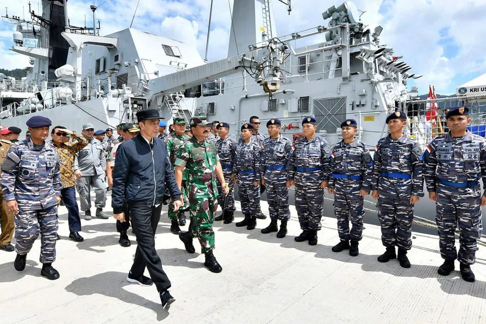 PANTAU KEADAAN: Encik Jokowi (depan) sedang memeriksa sekumpulan tentera semasa beliau melawat kepulauan Natuna baru-baru ini. - Foto AP 
