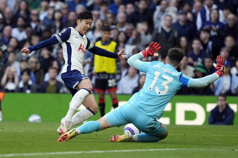 Son Heung-min (kiri) cuba menggelecek bola namun dijatuhkan penjaga gawang Bournemouth, Kepa Arrizabalaga, dalam percubaannya itu. Son kemudian menyempurnakan penalti untuk membantu Spurs seri 2-2 dengan pasukan lawan.