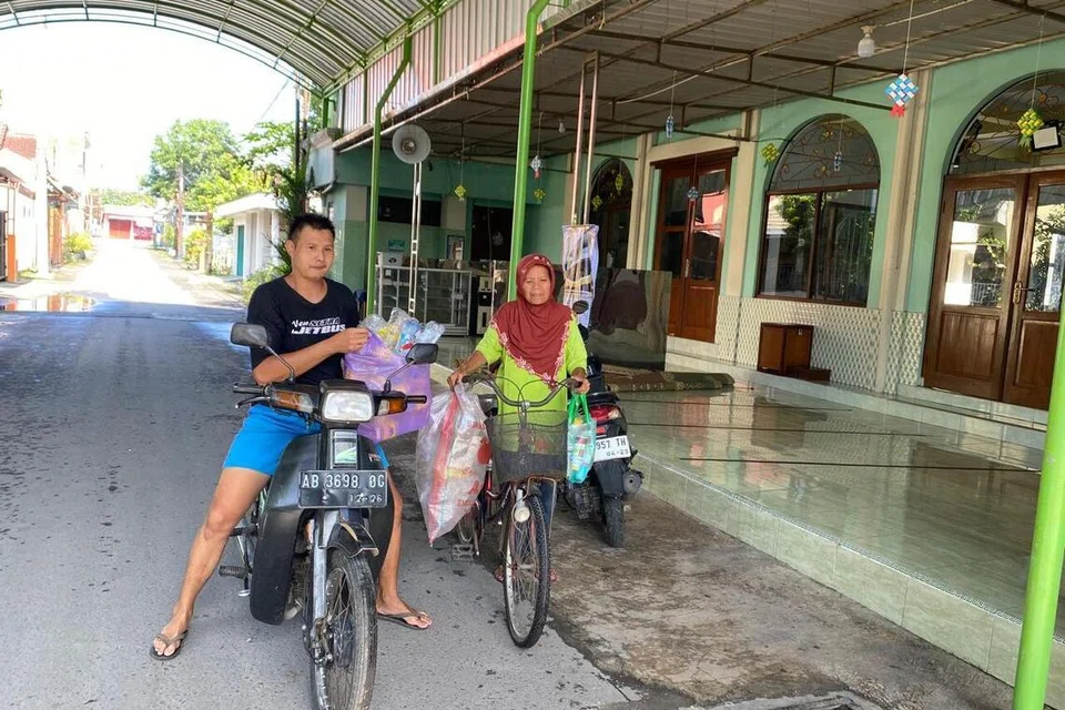 Encik Didik Supriyanto (kiri) dan Cik Suprih, datang ke Masjid Al Muharram di Bantul, Yogyakarta, Indonesia, untuk menyumbang bahan buangan di samping menjadi sukarelawan bagi mengasingkan bahan buangan yang diderma penduduk setempat. 
