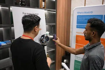 Worldcoin melibatkan pengguna merenung bebola perak dan membolehkan bahagian mata yang berwarna atau ‘iris’ mereka melalui pengimbasan sebagai pertukaran untuk ID digital dan token percuma.