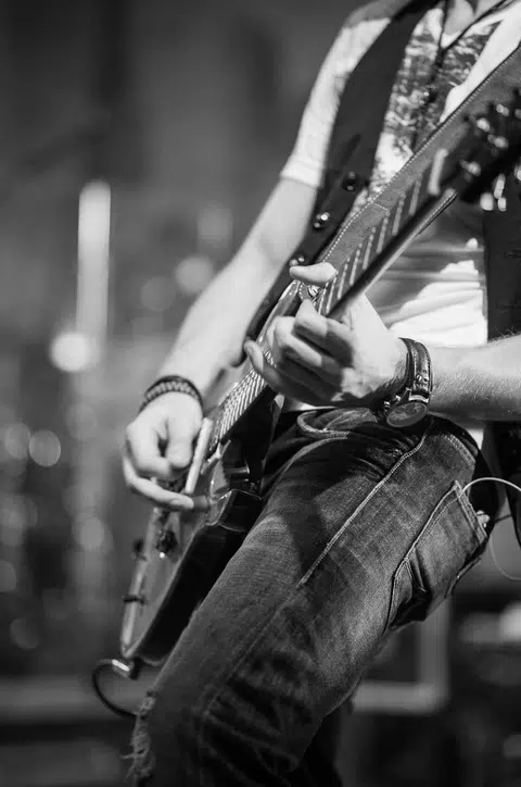 Aksi seseorang sedang ‘menggoreng’ gitar mengikut tempo yang rancak secara solo.