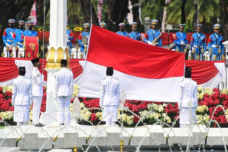 UPACARA NAIKKAN BENDERA: Satu upcara menaikkan bendera sempena sambutan Hari Kemerdekaan Indonesia ke-76 diadakan di istana Presiden di Jakarta semalam. Di beberapa jalan raya di bandar-bandar utama seperti Malang, penunggang motosikal dan pemandu kenderaan turut berhenti seketika sebagai tanda hormat kepada kibaran bendera. - Foto-foto REUTERS, AFP