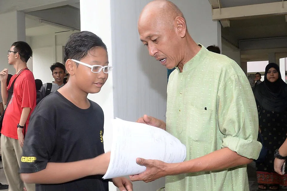 PEMERGIAN YANG TIDAK DIDUGA: Bapa Allahyarham Muhammad Hambali, Encik Sumathi Abdul Hamid, yang sedih dengan pemergian anaknya, semakin terharu dengan kehadiran rakan sekolah rendah Allahyarham, Haiqal Zulkifli (kiri). - Foto JOHARI RAHMAT 