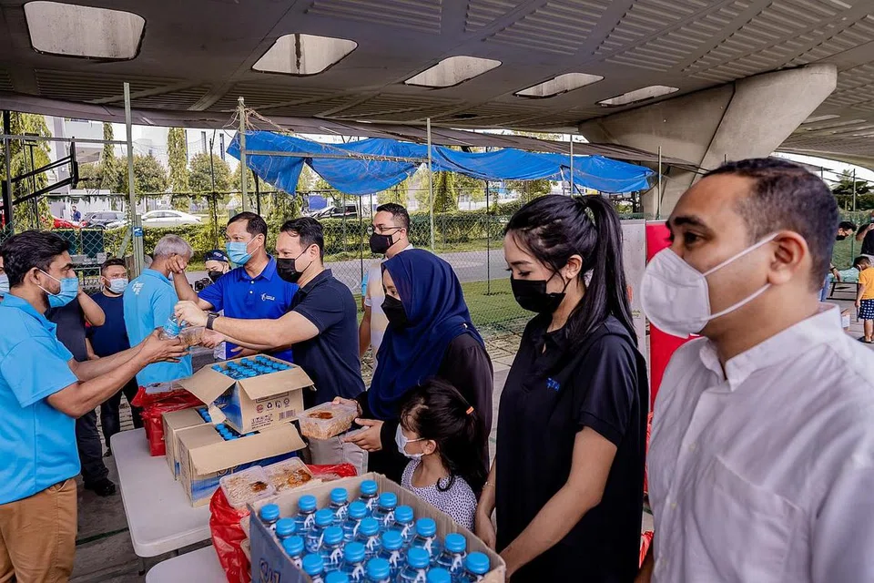 TERIMA KASIH 'BHAIYA': Menteri Negara Kanan (Pertahanan merangkap Tenaga Manusia), Encik Zaqy Mohamad (lima dari kanan), mengagihkan bungkusan nasi beriani kepada pekerja migran yang tinggal di dormitori kawasan Kaki Bukit pada hari pertama masyarakat Islam di sini mula berpuasa di bawah inisiatif Terima Kasih Bhaiya anjuran Forum Belia Islam (MYF).